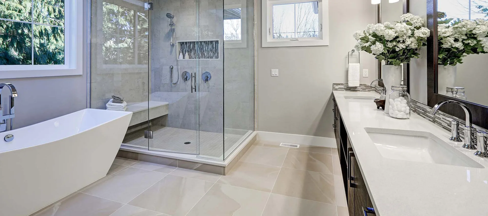 Neutral tile flooring and shower tile in a spacious bathroom